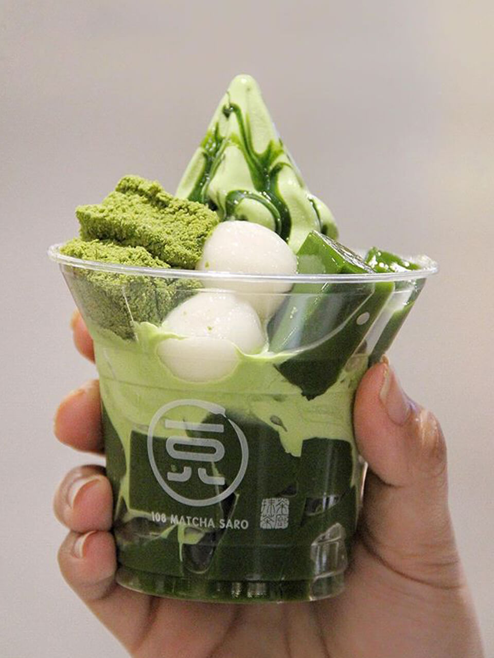 Hand holding a cup of matcha ice cream